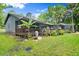 Back exterior of house with a covered porch, screened lanai, and backyard at 96 Hollow Branch Xing, Ormond Beach, FL 32174