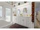 Bathroom featuring a soaking tub, double vanity with mirrors and exterior access at 96 Hollow Branch Xing, Ormond Beach, FL 32174