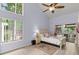 Brightly lit bedroom with high ceilings, fan, ensuite, and sliding door access to the outdoor deck at 96 Hollow Branch Xing, Ormond Beach, FL 32174
