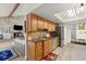 Bright kitchen featuring wood cabinets, granite countertops, tile backsplash and a skylight at 96 Hollow Branch Xing, Ormond Beach, FL 32174
