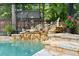 Close-up of rock waterfall feature in screened-in pool area at 96 Hollow Branch Xing, Ormond Beach, FL 32174