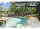Screened-in pool with rock waterfall feature and lush landscaping at 96 Hollow Branch Xing, Ormond Beach, FL 32174