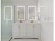 Modern bathroom with double vanity, illuminated mirrors, and glass-enclosed shower at 2600 Scottville Ave, Deltona, FL 32725