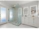 Modern bathroom boasts a glass-enclosed shower, dual vanity with lighted mirrors and sleek fixtures for a spa-like experience at 2600 Scottville Ave, Deltona, FL 32725