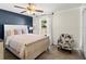 Cozy bedroom with a blue accent wall, a comfy bed, lots of natural light, and a decorative chair for relaxing at 2600 Scottville Ave, Deltona, FL 32725