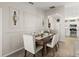 Elegant dining room with seating for six, decorative wall sconces, and views into the kitchen at 2600 Scottville Ave, Deltona, FL 32725