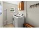 Functional laundry room with a modern washer and dryer, storage cabinets, and a 'Welcome' decoration at 2600 Scottville Ave, Deltona, FL 32725