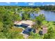 Aerial view of lakefront home surrounded by lush greenery showcasing serene waterfront living at 10 Madera Rd, Debary, FL 32713