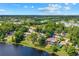 Stunning aerial view showcases a lakeside property nestled among lush greenery and neighborhood charm under a bright sky at 10 Madera Rd, Debary, FL 32713