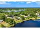 Expansive aerial shot highlights a tranquil lakeside property surrounded by verdant trees under clear blue skies at 10 Madera Rd, Debary, FL 32713