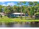 Back view of charming home overlooking lake, featuring a screened-in porch and expansive yard at 10 Madera Rd, Debary, FL 32713