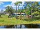 Back of house with lake view and yard with fire pit and lounge area at 10 Madera Rd, Debary, FL 32713