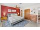 Stunning bedroom showcases a red accent wall, wood dressers, and modern decor at 10 Madera Rd, Debary, FL 32713