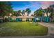 Charming blue single-story home with a manicured lawn and covered carport at sunset at 10 Madera Rd, Debary, FL 32713