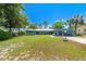Inviting single-story home with a well-manicured lawn, carport, and charming curb appeal on a sunny day at 10 Madera Rd, Debary, FL 32713