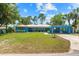 Charming blue single-story home with a manicured lawn and covered carport under bright blue sky at 10 Madera Rd, Debary, FL 32713