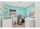 Functional laundry room featuring modern washer and dryer units with a utility sink and lake view at 10 Madera Rd, Debary, FL 32713