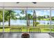 Enjoy serene lake views from the screened lanai, furnished with a dining table and chairs at 10 Madera Rd, Debary, FL 32713