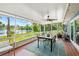 Enjoy outdoor living on the screened porch with a ceiling fan, dining set and lake views at 10 Madera Rd, Debary, FL 32713