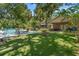 Expansive backyard features an in-ground pool, fire pit, patio, lush landscaping, and mature trees at 1056 Reynolds Rd, De Leon Springs, FL 32130