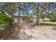 View of backyard with barn and mature trees creating shade with a small vineyard and farm house at 1056 Reynolds Rd, De Leon Springs, FL 32130