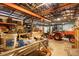Interior view of a large barn with equipment, tools, machinery, and multiple orange tractors at 1056 Reynolds Rd, De Leon Springs, FL 32130