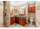 Bathroom featuring double sink vanity with granite countertop, warm wood cabinetry, recessed lighting, and a tiled walk-in shower at 1056 Reynolds Rd, De Leon Springs, FL 32130