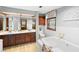 Bathroom with double sink vanity with granite countertop, tub, tile floor, and window overlooking the yard at 1056 Reynolds Rd, De Leon Springs, FL 32130