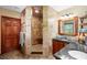 Elegant bathroom featuring a tiled walk-in shower with a seat, granite countertop vanity, and warm wood accents and cabinetry at 1056 Reynolds Rd, De Leon Springs, FL 32130