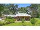 Exterior shot of home, showing porch with seating and lush landscaping at 1056 Reynolds Rd, De Leon Springs, FL 32130