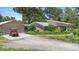 View of home with a brick facade, a detached garage, and a well-maintained lawn at 1056 Reynolds Rd, De Leon Springs, FL 32130