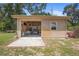 Detached garage with open door revealing ample storage space, set in a green yard, demonstrating functionality at 1056 Reynolds Rd, De Leon Springs, FL 32130