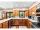 A cozy kitchen featuring wood cabinets, white countertops, and a garden window overlooking lush outdoor greenery at 1056 Reynolds Rd, De Leon Springs, FL 32130