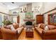 Inviting living room with a stone fireplace, vaulted ceilings, hardwood floors, and comfortable leather furniture at 1056 Reynolds Rd, De Leon Springs, FL 32130