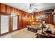 Cozy living room with wood paneling, leather sofa, and rustic decor at 1056 Reynolds Rd, De Leon Springs, FL 32130