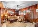 Inviting living room featuring wood paneling, leather sectional and rustic accents at 1056 Reynolds Rd, De Leon Springs, FL 32130
