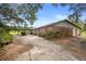 Brick outbuilding and cracked driveway surrounded by mature trees and flourishing grape vines at 1056 Reynolds Rd, De Leon Springs, FL 32130