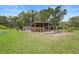 Open outbuilding filled with farm equipment, including a tractor, on a large grassy lot at 1056 Reynolds Rd, De Leon Springs, FL 32130