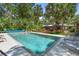 Tranquil pool with lounge chairs, surrounded by lush landscaping, with a deck perfect for relaxation and entertaining at 1056 Reynolds Rd, De Leon Springs, FL 32130