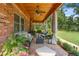 Charming porch featuring comfortable seating, potted plants, and brick detailing, creating an inviting outdoor space at 1056 Reynolds Rd, De Leon Springs, FL 32130