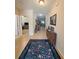 Inviting hallway with tile flooring leads to a living area, complemented by a decorative rug and wooden accent furniture at 110 No Name Key Dr, Deland, FL 32720