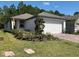 Charming single-story home featuring a two-car garage, a well-manicured lawn, and vibrant landscaping at 112 Lost Ball Dr, Daytona Beach, FL 32124