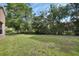 Large backyard with lush green lawn and mature trees offering lots of outdoor space at 1125 Stillwater Dr, Deland, FL 32720