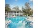 Community pool featuring a large deck with seating and a view of mature trees in a resort setting at 1125 Stillwater Dr, Deland, FL 32720