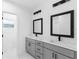 Modern bathroom features dual sinks with gray cabinetry and framed mirrors at 1163 W Hancock Dr, Deltona, FL 32725