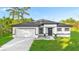 Charming single-story home featuring a two-car garage, landscaped yard, and modern architectural details in neutral tones at 1163 W Hancock Dr, Deltona, FL 32725