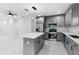 Open concept kitchen with a center island, stainless steel appliances, gray cabinetry, and modern lighting fixtures in a spacious layout at 1163 W Hancock Dr, Deltona, FL 32725