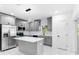 Featuring grey cabinets, a marble countertop island, modern lighting, and stainless steel appliances, this bright kitchen has it all at 1163 W Hancock Dr, Deltona, FL 32725