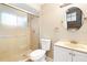 Bathroom with tiled shower, vanity with sink, toilet, and round mirror at 1204 Lawrence Ave, Deltona, FL 32725