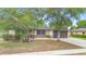Traditional home featuring well-kept front lawn and mature trees, adding to the curb appeal at 1204 Lawrence Ave, Deltona, FL 32725